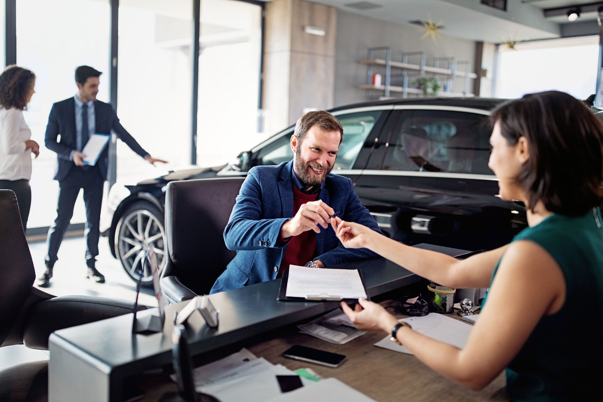 Man is buying/leasing new car and signing a contract